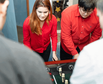 employees playing table football in the office of academy smart